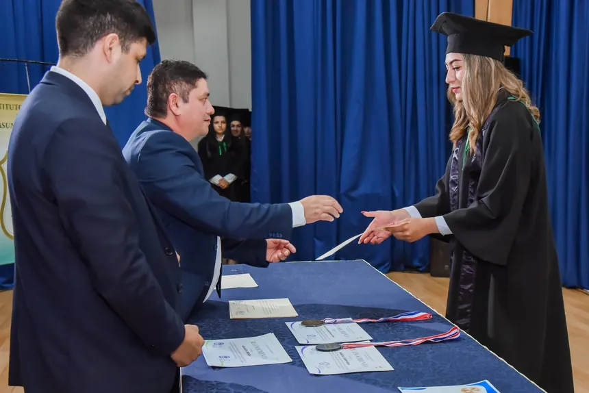 Una egresada recibe su título de manos de las autoridades del instituto